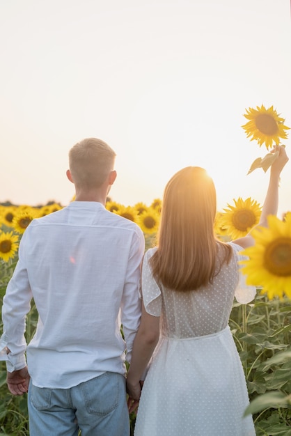 Beautiful couple having fun in sunflowers fields