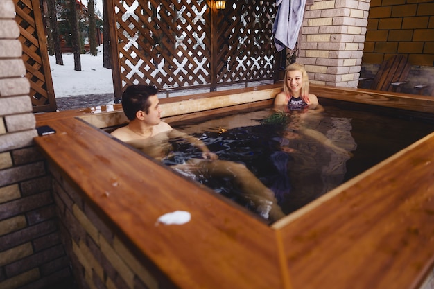 Beautiful couple in the hot tub in the winter