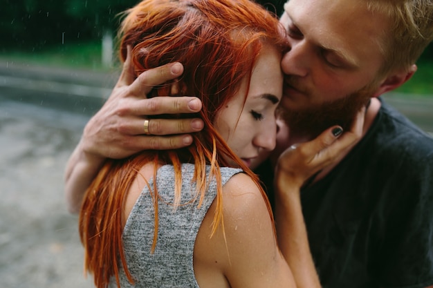 Beautiful couple hugging on outside in the rain