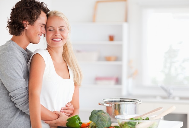 Beautiful couple hugging while cooking