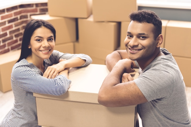 Beautiful couple is leaning on the moving boxes