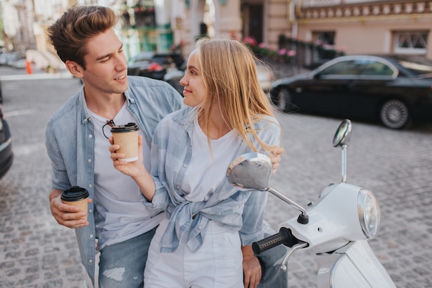 Beautiful couple is sitting together on motorcycle anf looking at each other