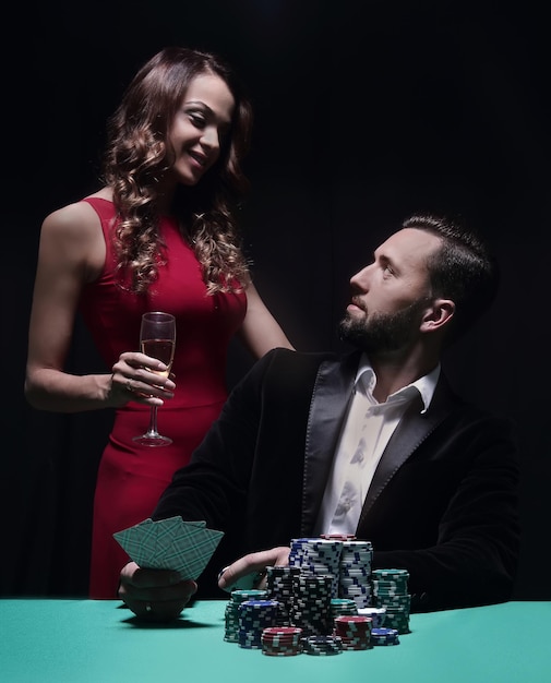 Beautiful couple looking at playing cards at poker