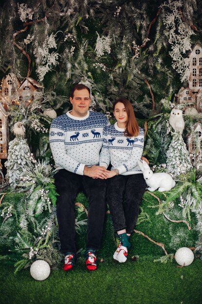 beautiful couple in love in cozy sweaters with christmas print