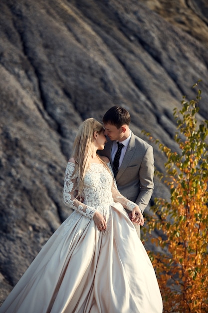 Bella coppia innamorata su un paesaggio favoloso, matrimonio nella natura, amore bacio e abbraccio