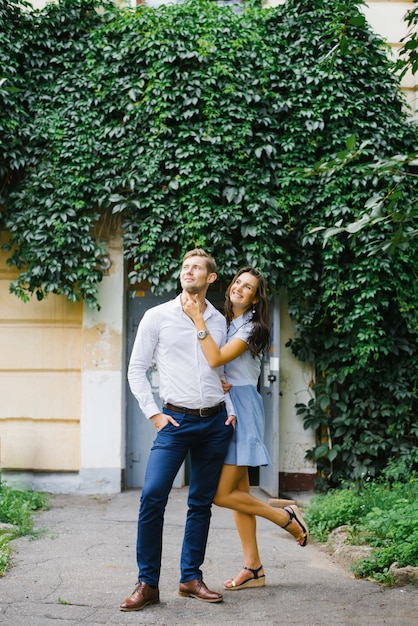 A beautiful couple in love, a guy and a girl, have fun free time, walking through the city streets in the summer