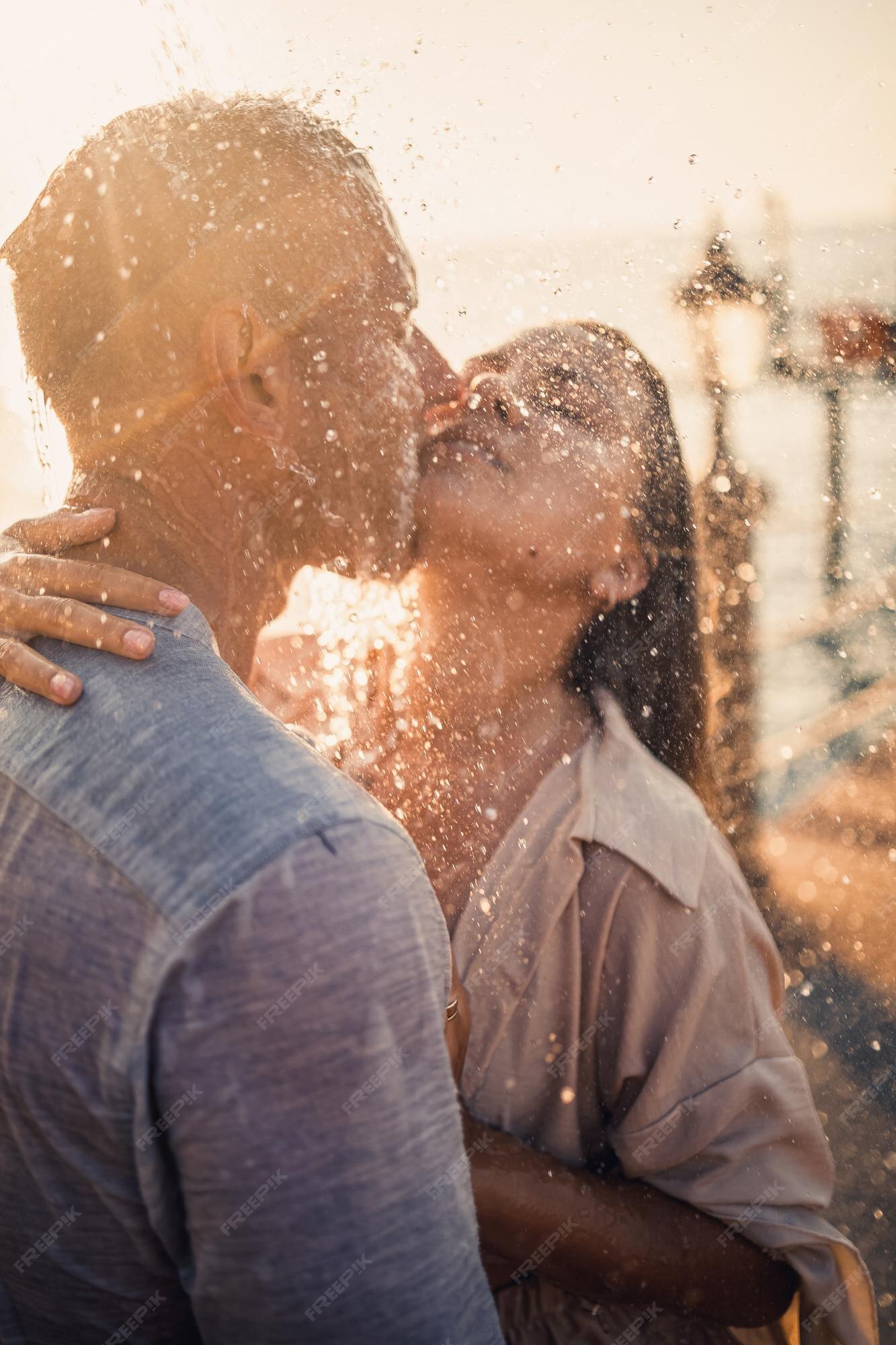 Premium Photo | Beautiful couple in love hugs and kisses under the streams  of water in a luxury spa hotel on their honeymoon vacation in the tropics  selective focus