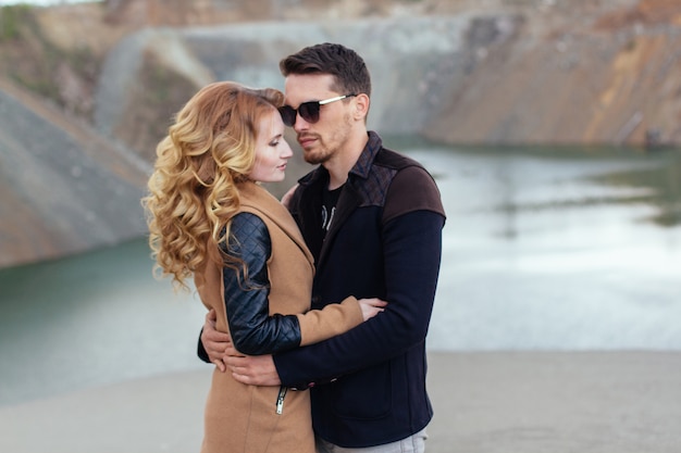 Beautiful couple in love on Valentine's Day. Happy young couple walking on the sandy mountains on a cloudy day