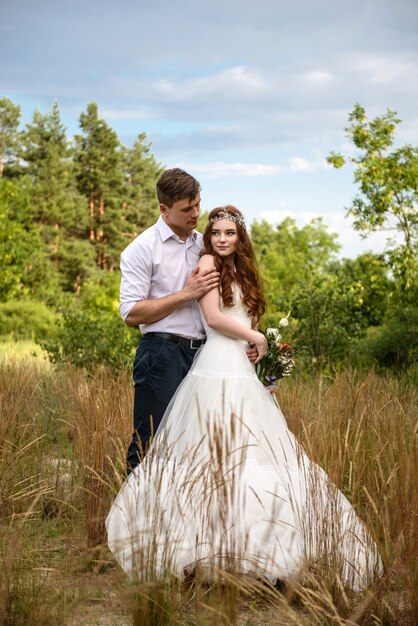 Beautiful couple of lovers bride and groom in the forest