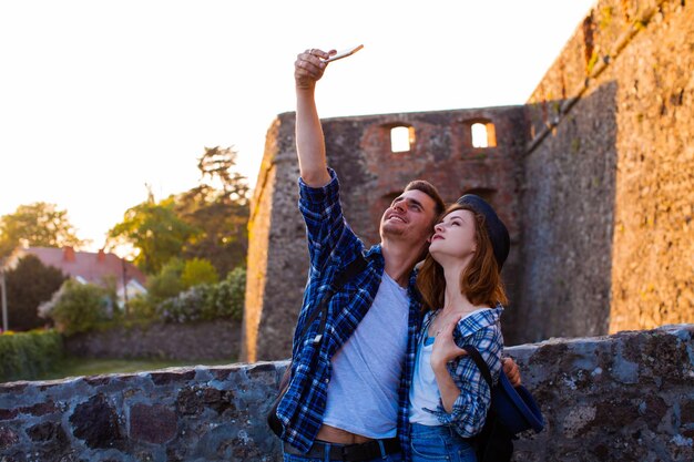 The beautiful couple make a common selfie near the castle in the summer