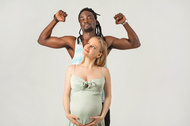 Bella coppia di uomo e donna incinta su uno sfondo bianco