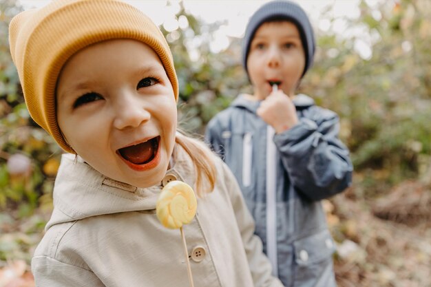 写真 男の子と女の子の子供たちの美しいカップルは、お互いに誠実な友情を持っており、公園を散歩して写真を撮るために楽しんでポーズをとっています