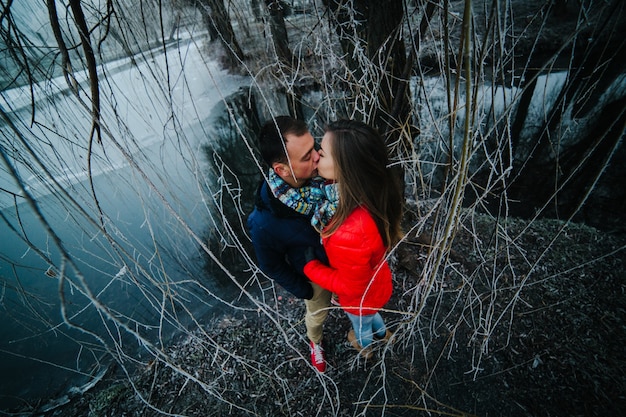 Beautiful couple posing near a frozen river in the park