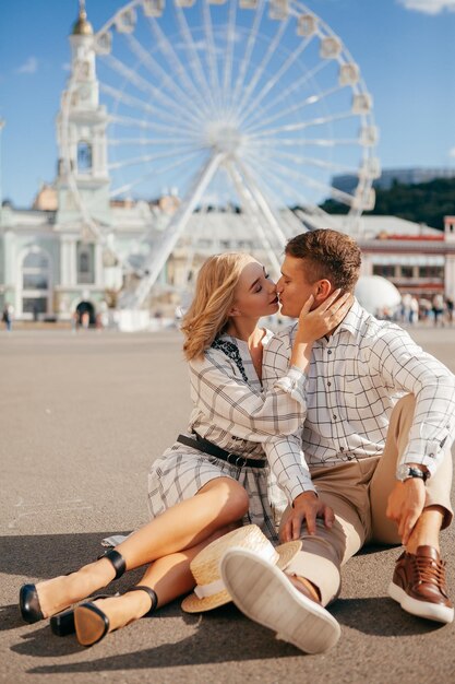 Beautiful couple smiling and posing near ferris wheel