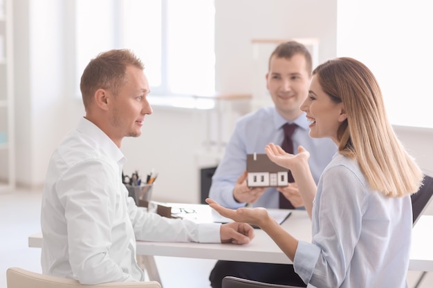 Beautiful couple with real estate agent in office