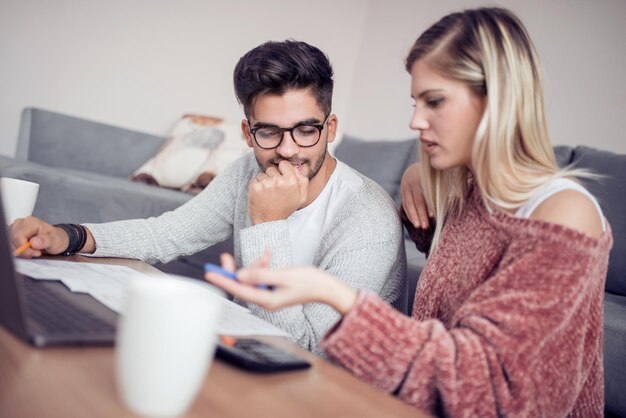 Beautiful couple working on laptop at home