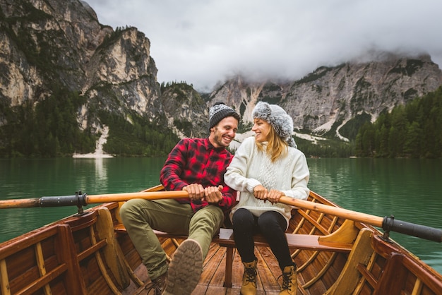 Beautiful couple of young adults visiting an alpine lake at Braies, Italy
