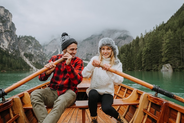 Bella coppia di giovani adulti che visitano un lago alpino a braies italia