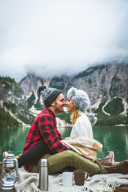 Beautiful couple of young adults visiting an alpine lake at Braies Italy