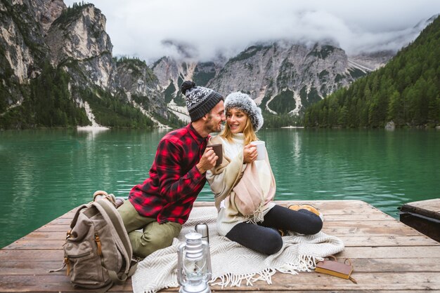 Beautiful couple of young adults visiting an alpine lake at Braies Italy