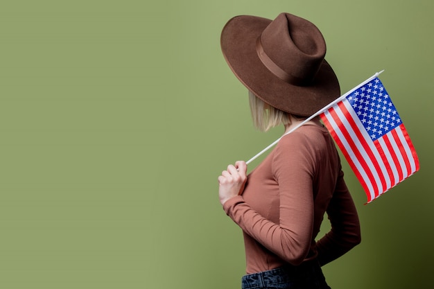 Beautiful cowgirl in a hat with United States of America flag
