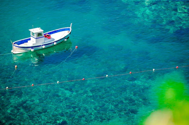 ボートとイタリアの海岸、マナローラ、リグーリア州、ヨーロッパの澄んだ青緑色の水と美しい居心地の良い湾