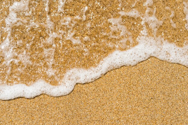 Foto splendida acqua di mare cristallina, onde delicate che si infrangono sulla spiaggia di sabbia dorata.