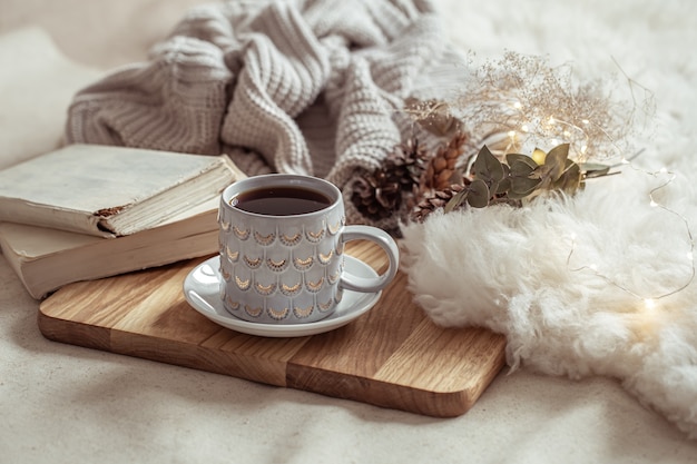 Photo a beautiful cup with a hot drink on a wooden tray. home comfort concept.