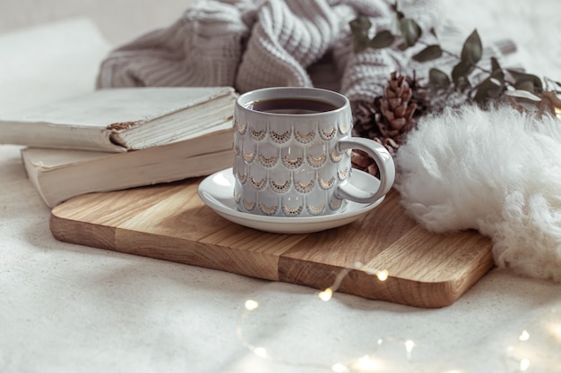 A beautiful cup with a hot drink on a wooden tray. Home comfort concept.