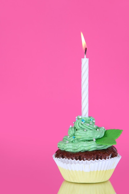 Photo beautiful cupcake with candle on pink background