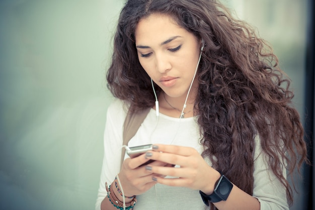 beautiful curly long brunette hair moroccan woman using smart phone