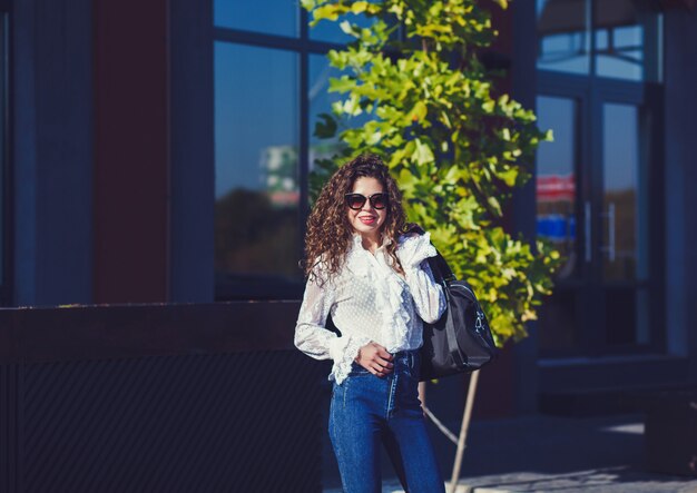 Beautiful curly young woman in sunglasses