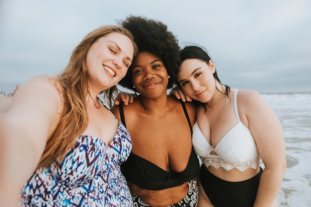 Beautiful curvy women taking a selfie at the beach