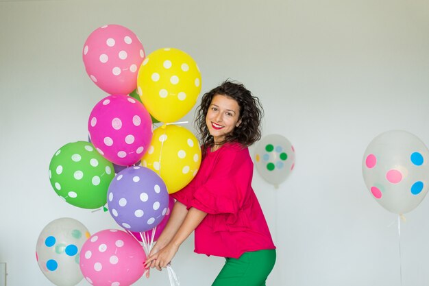 Beautiful cute cheerful girl with colored balloons