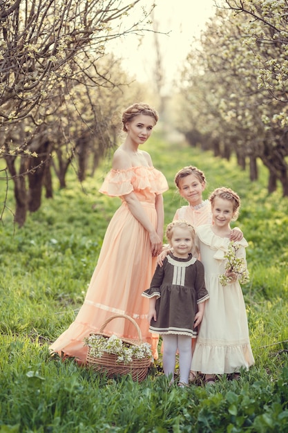 Beautiful cute girls in the garden enjoying the arrival of spring dresses in vintage style Concept of childhood tenderness