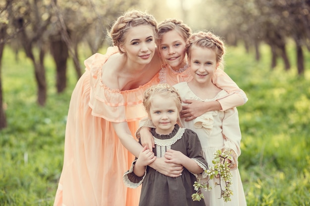 Beautiful cute girls in the garden enjoying the arrival of spring dresses in vintage style Concept of childhood tenderness