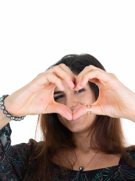 Beautiful cute happy young woman show fingers love heart sign front eyes with hand joy