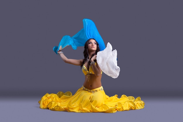 Beautiful dancer in yellow costume sit on floor