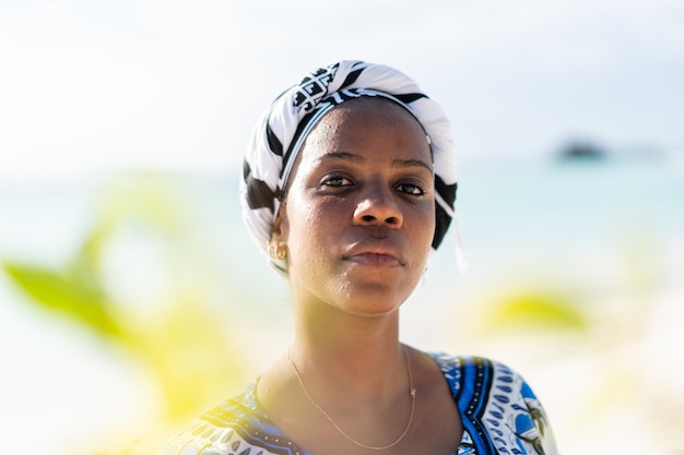 Beautiful dark skin young woman between palm branches on beach photo