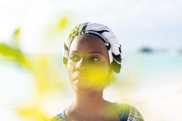 Beautiful dark skin young woman between palm branches on beach photo