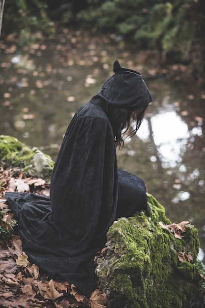 beautiful dark vampire woman with black mantle and hood