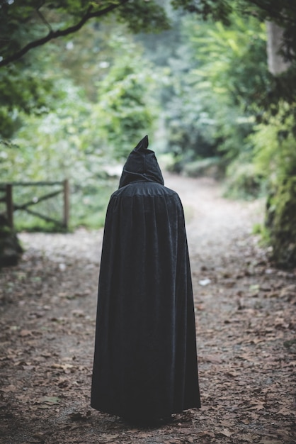 Bella donna vampiro scuro con mantello nero e cappuccio