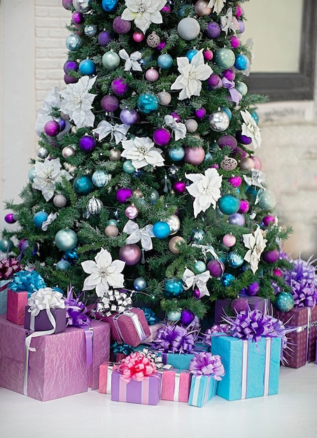 Beautiful decorated Christmas tree Under it are gifts The main colors of the toys white purple