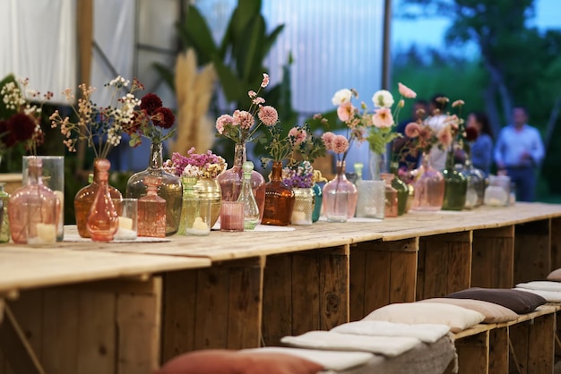 Beautiful decoration with flowers and colorful glass vases