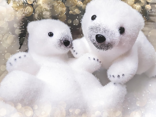 Beautiful decorative Christmas and Happy New Year composition of two cute little white polar bears, sparkles, glare and falling snow. Shining celebration background