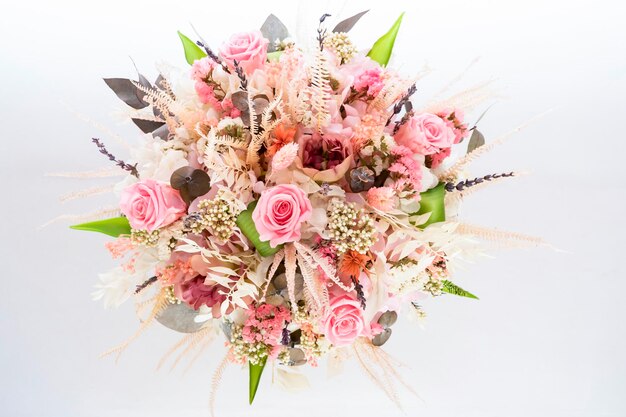 A beautiful delicate bouquet of stabilized flowers roses dried flowers twigs of leaves on a light ba