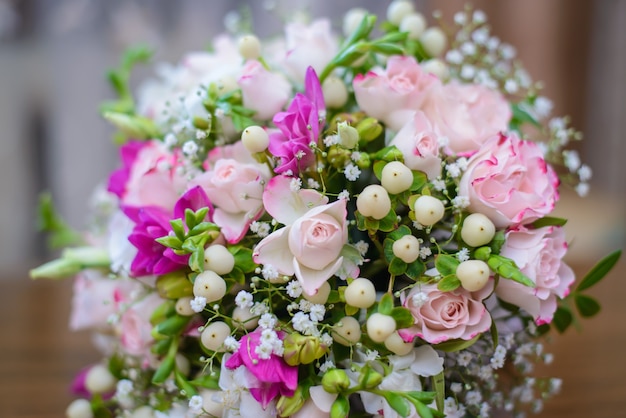 Beautiful delicate wedding bouquet for the bride of pink flowers and white buds close up