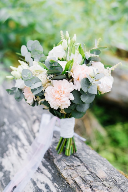 Beautiful delicate wedding bouquet in rustic style with eucalyptus and carnations, eustoms for the bride