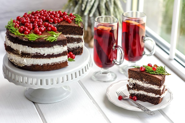 Красивый вкусный торт с ярко-красными ягодами на рождественском столе
