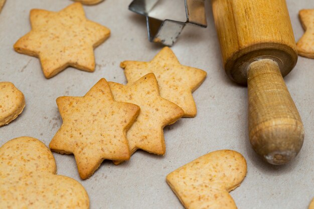 Foto bellissimo e delizioso pan di zenzero natalizio sullo sfondo di legno e protuberanze in primo piano